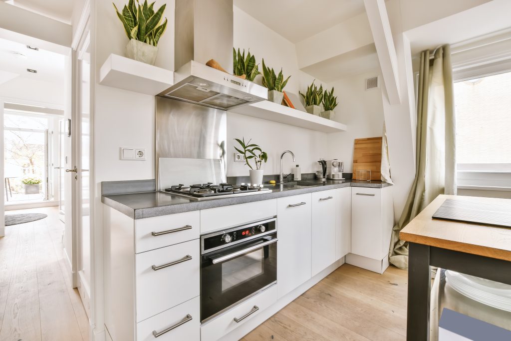 The interior of an attractive kitchen with lots of pots of flowers in daylight